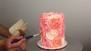 apply golf leaf to cake with a paintbrush for edible gold cakes