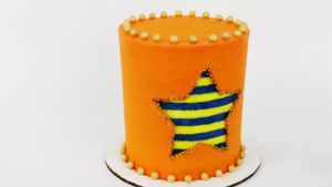 carved buttercream striped cake with gold sprinkles