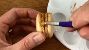 painting macarons gold with gold luster dust paint for edible gold cakes