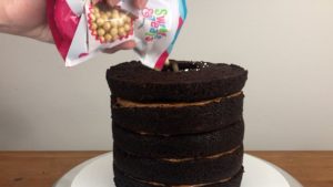 pour sprinkles into piñata gold sprinkle explosion cake