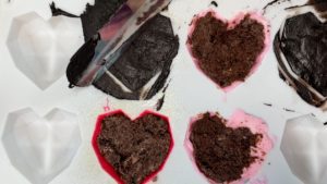 scrape excess chocolate off Geometric Heart mold with offset spatula for Simple Stylish Designs