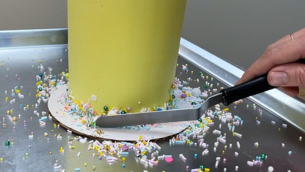 press sprinkles into frosting to make a border How to Make a Birthday Cake