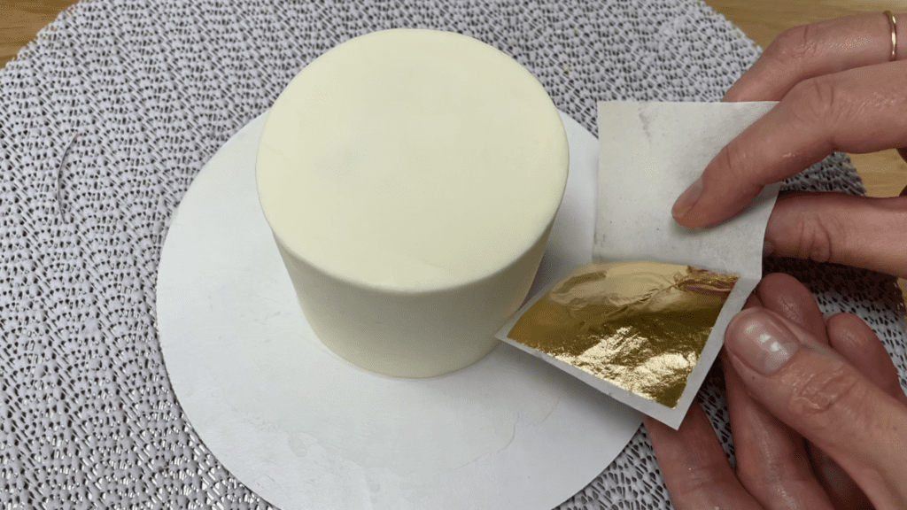 press gold leaf onto frosting gold cakes 3 ways