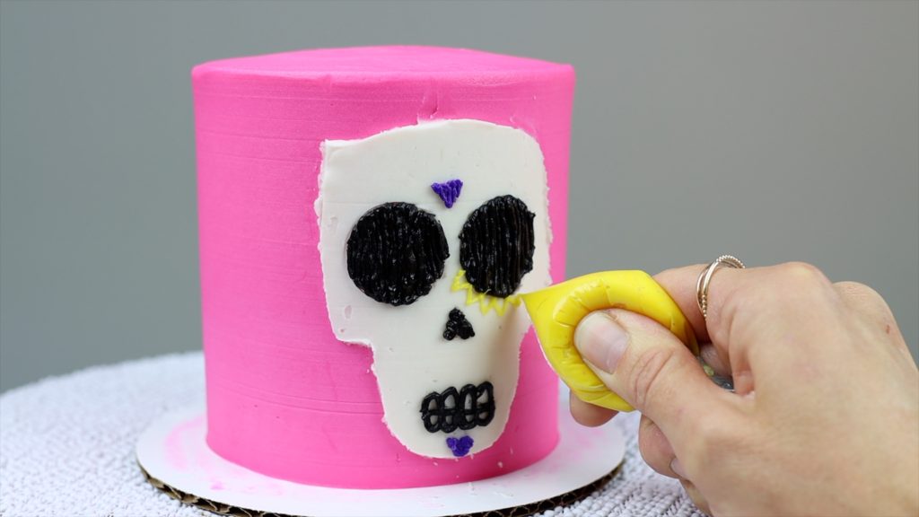 pipe details onto cake with ziploc bags 10 Halloween Cake Hacks