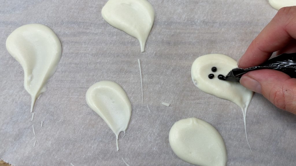 pipe faces onto chocolate ghosts 10 Halloween Cake Hacks