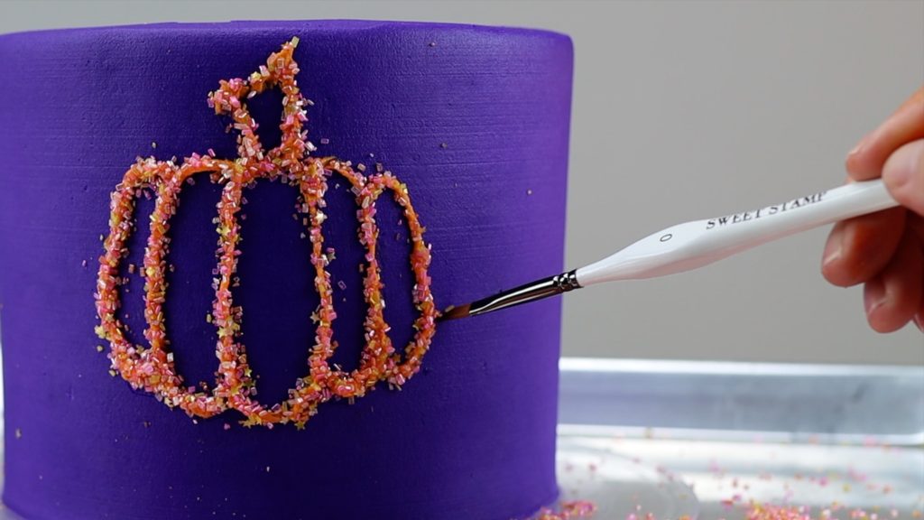 press sprinkles into piped buttercream design 10 Halloween Cake Hacks