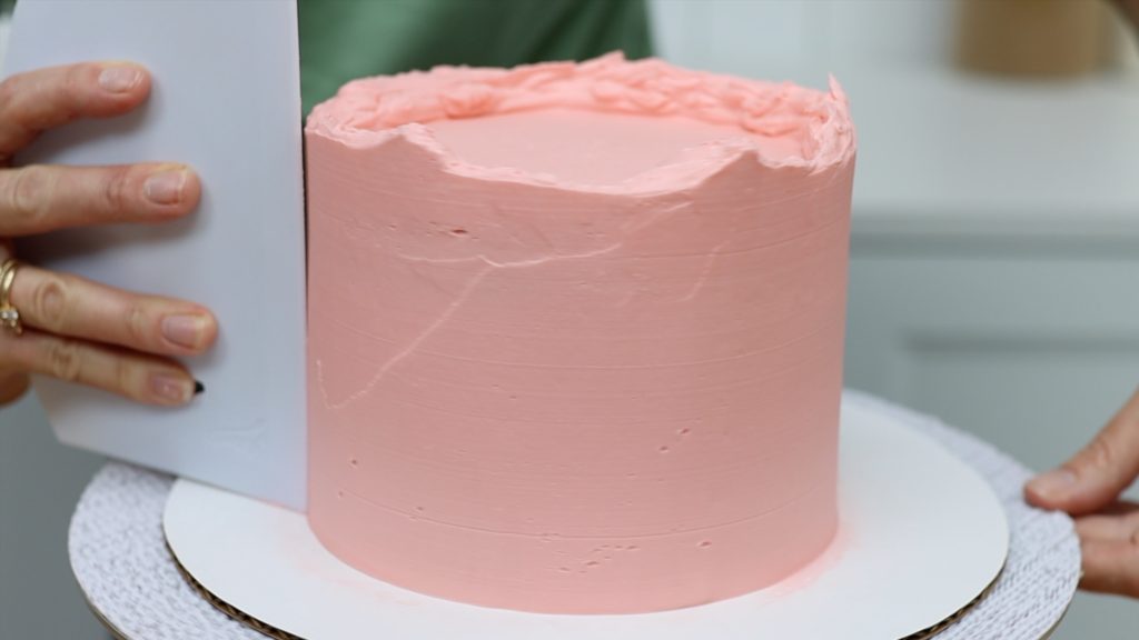 using a cake scraper to smooth frosting on cake 10 Tips for your First Cake