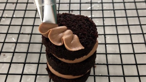 pipe petal flower onto mini cake with best chocolate buttercream frosting recipe tutorial