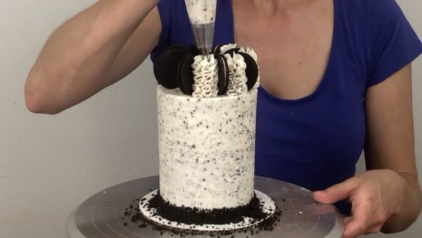 pipe frosting swirls with a 1M piping tip on cookies and cream cake