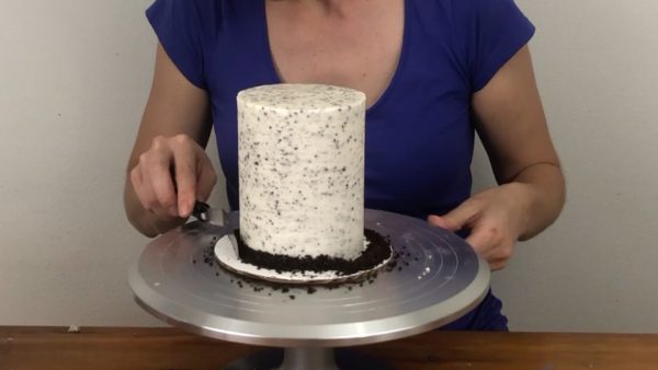 push oreo crumbs into frosting on cookies and cream cake