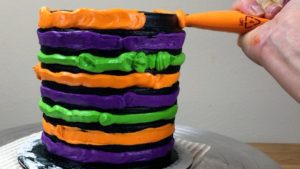 pipe coloured buttercream into stripe grooves Halloween Cake With Gold Buttercream Pumpkins