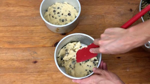 push chocolate chip cookie dough into cake pans to make chocolate chip cookie cake