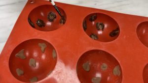 paint leopard print spots into hot chocolate bomb mold for trendy neon leopard print cake