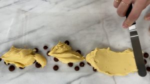 spread yellow buttercream over leopard print spots for trendy neon leopard print cake