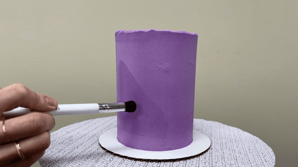 brush cake with vodka to apply gold leaf onto a stencil How To Use Gold Leaf On Cakes