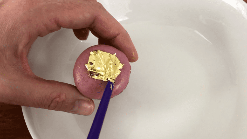 brush gold leaf onto macarons How To Use Gold Leaf On Cakes