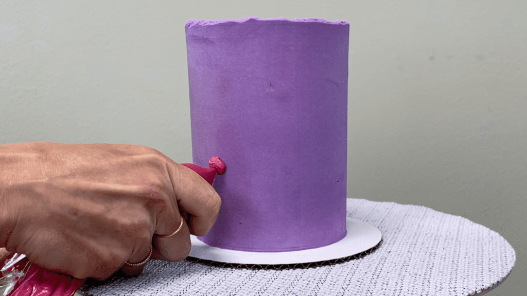 pipe buttercream dots onto cake with a ziploc bag 5 Cakes You Can Decorate in 5 Minutes