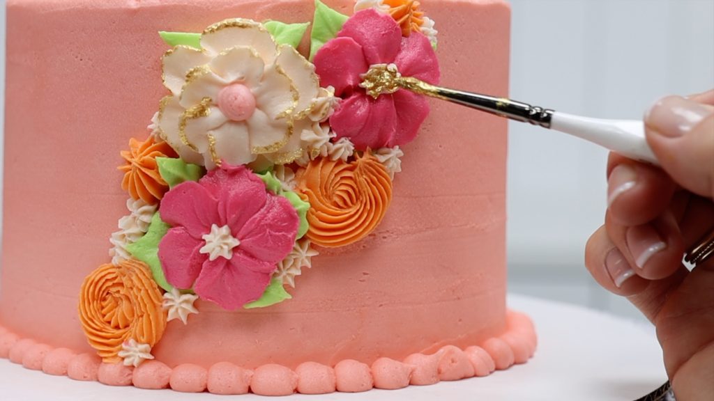 brush edible gold paint onto piped flowers on cake 10 ways to make your cakes look professional