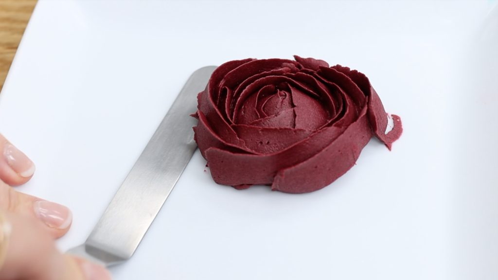 lift frozen rose with offset spatula to attach to cake 4 Stunning Homemade Cake Toppers