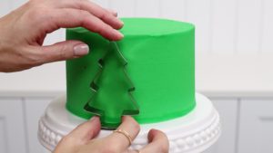 outline shapes on cake with cookie cutter 5 Christmas Cake Decorating Ideas