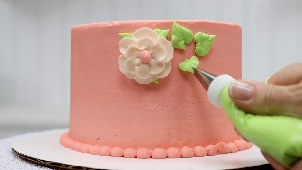 pipe leaves with a leaf tip #352 to attach flowers to the cake 10 ways to make your cakes look professional