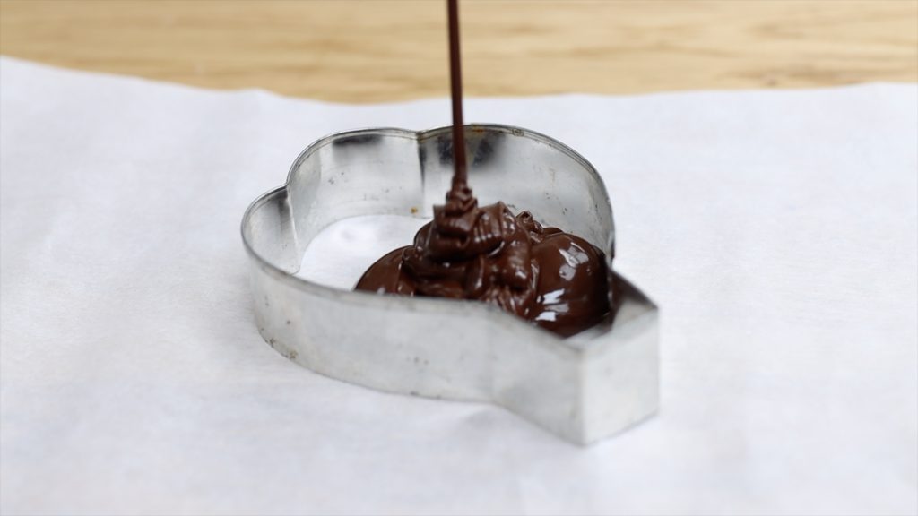 pour melted chocolate into a cookie cutter 4 stunning Homemade Cake Toppers