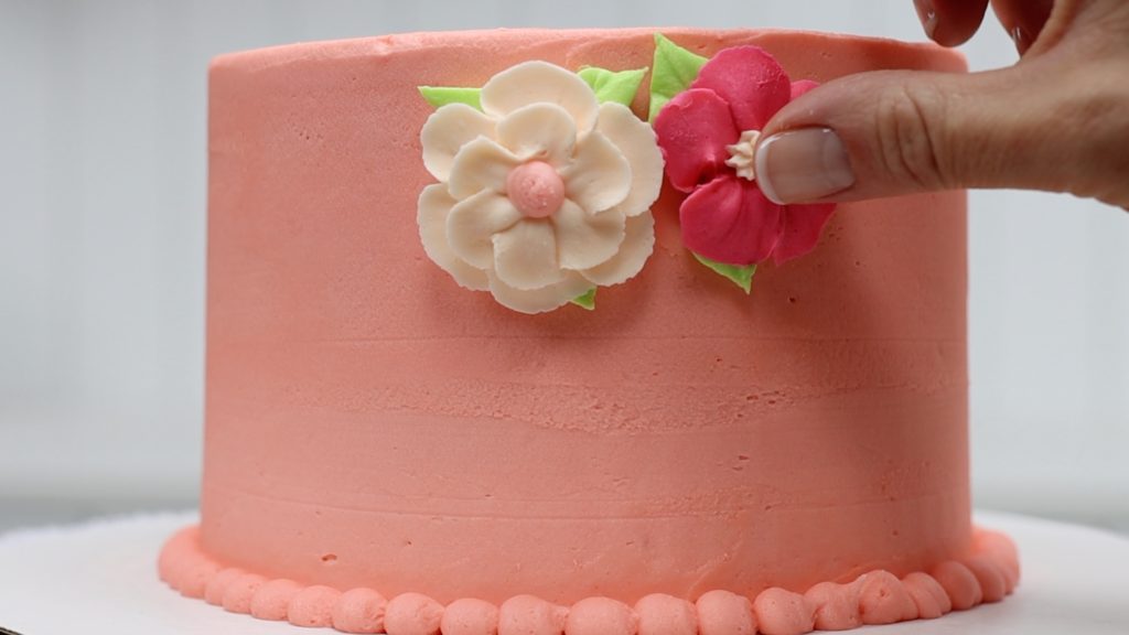 press frozen flowers into the frosting on the cake 10 ways to make your cakes look professional