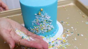 press sprinkles onto stencil design 5 Christmas Cake Decorating Ideas