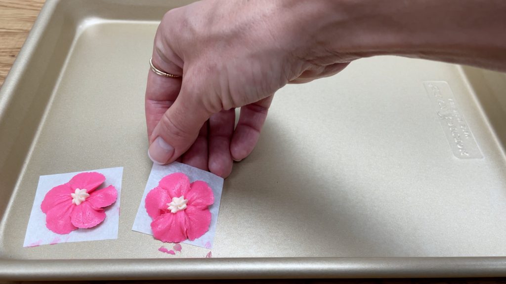 slide flowers on parchment paper onto a tray or plate 10 ways to make your cakes look professional