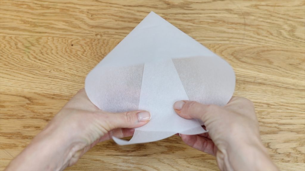 fold parchment triangle into a cone to make a piping bag 11 BAKERY SECRETS for Cake Decorating