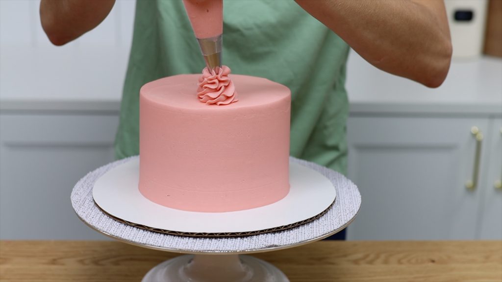 use leftover buttercream from frosting cake to pipe swirls onto cake 11 BAKERY SECRETS for Cake Decorating