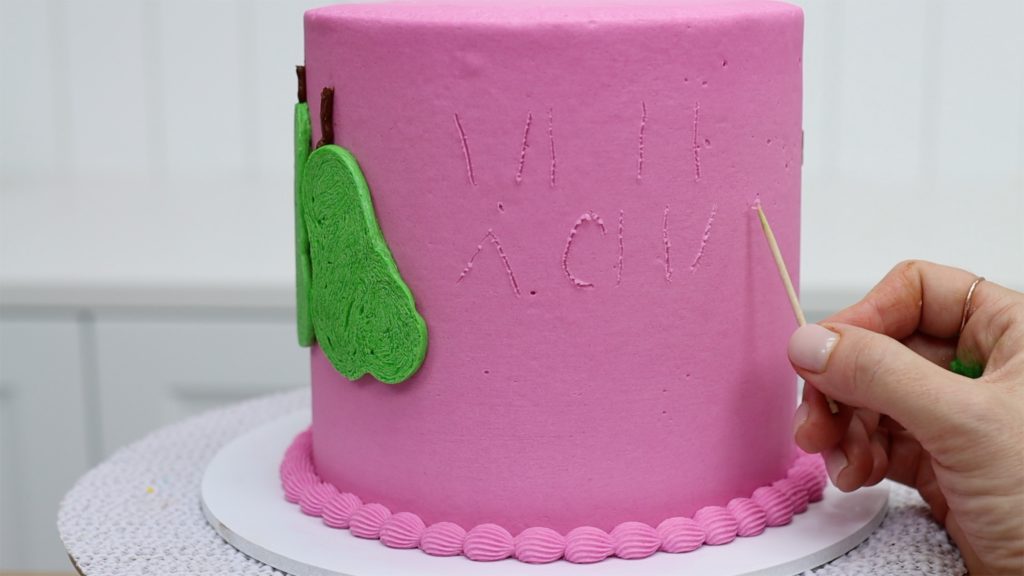 outline letters with a toothpick before piping a message onto a cake