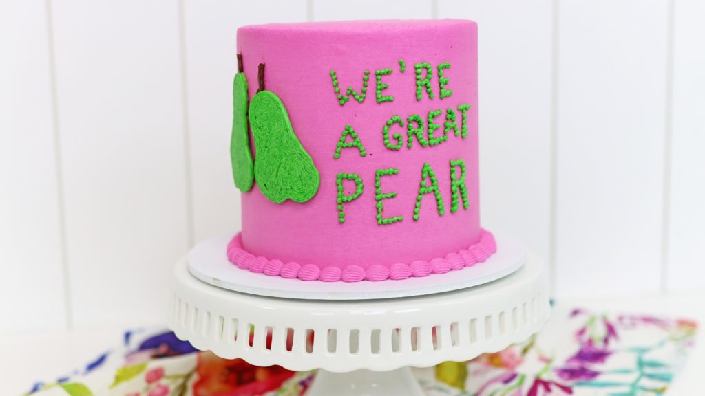 pointillist writing on a cake using piped dots of buttercream