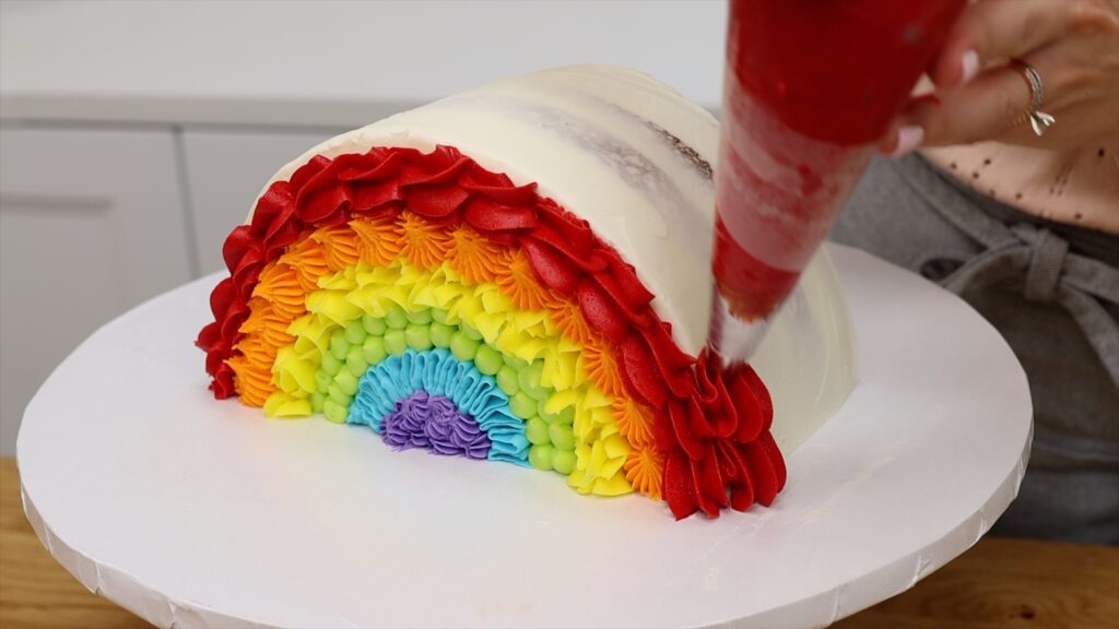 How To pipe rainbow frosting onto a semicircle Rainbow Cake | British Girl Bakes