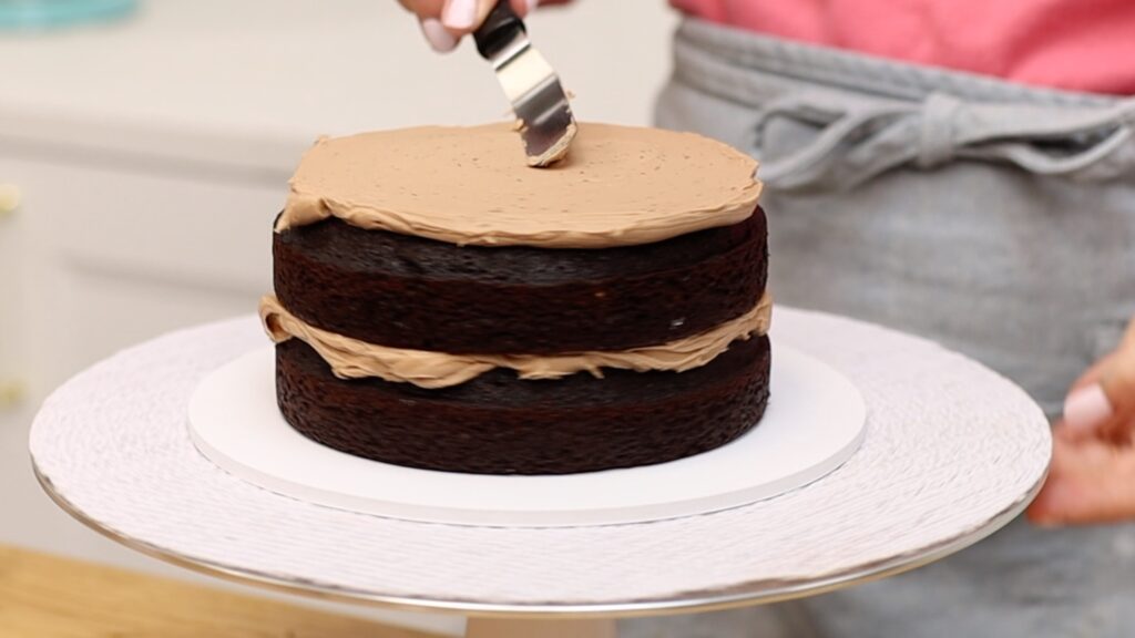 assemble Chocolate Peanut Butter Cake with chocolate buttercream filling between perfect chocolate cake layers | British Girl Bakes