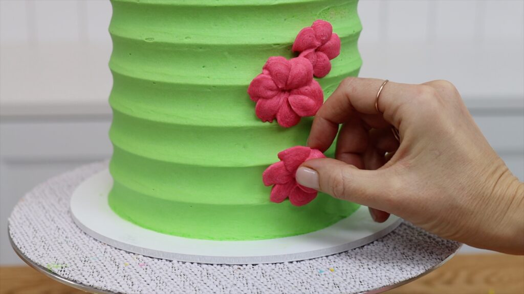 how to attach piped buttercream flowers onto a cake Parchment Paper Cake Hacks | British Girl Bakes