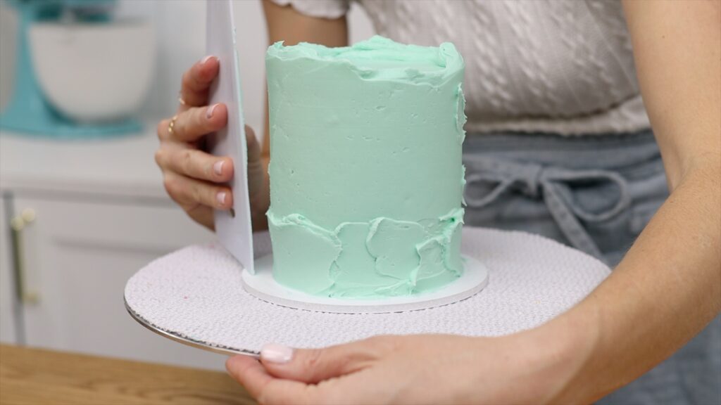 how to hold your cake comb to make the sides of the cake frosting straight | British Girl Bakes