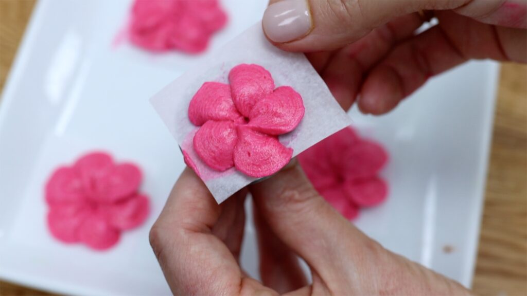 how to transfer piped flowers onto a cake with Parchment Paper | British Girl Bakes