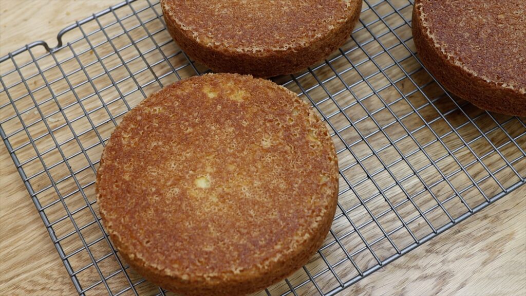 vanilla cake layers with golden crust on cooling rack