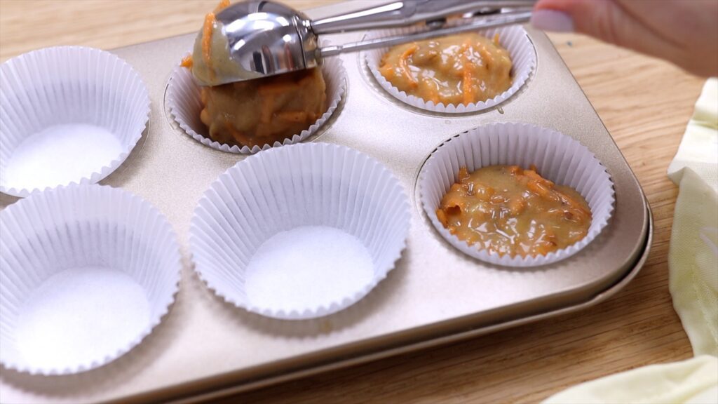 use ice cream scoop as secret tool for cake decorating to divide batter between cupcake wrappers