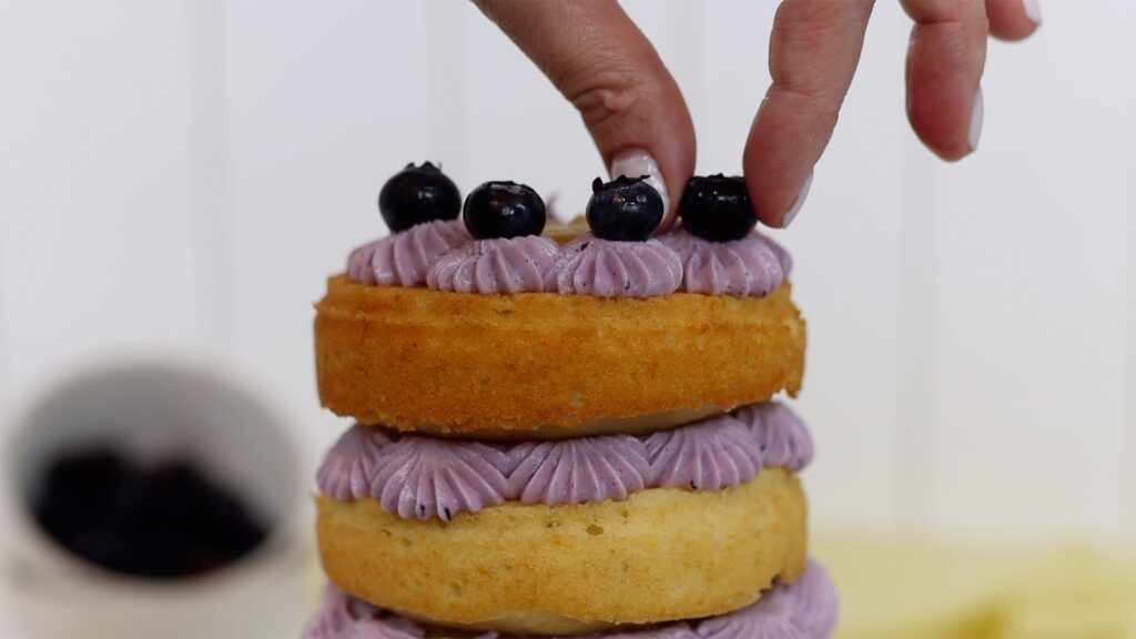 attach berries to piping on a cake