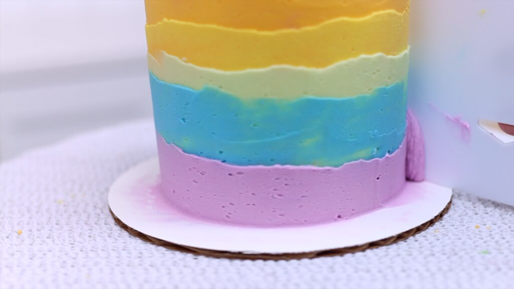 how to layer rainbow buttercream frosting on a cake