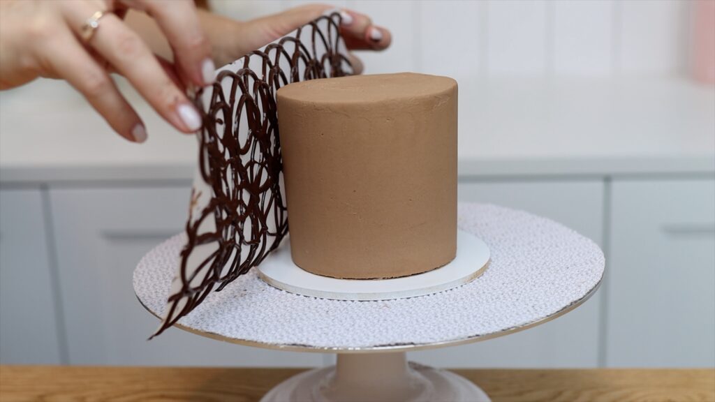 how to wrap a chocolate design on parchment paper around a cake