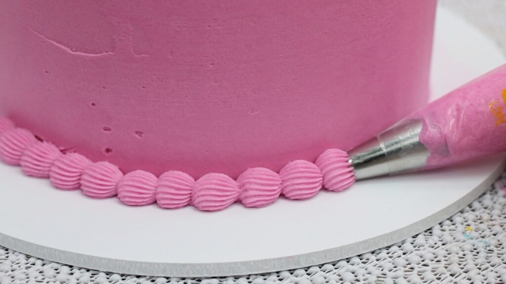 piping a star tip border on cake