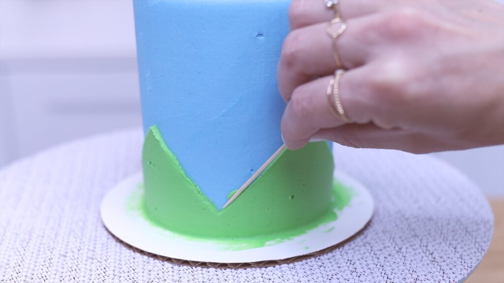 scrape frosting smudges off cake with a toothpick