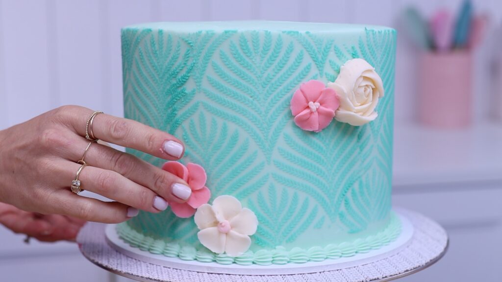 use piped flowers to cover up imperfections in frosting on cake