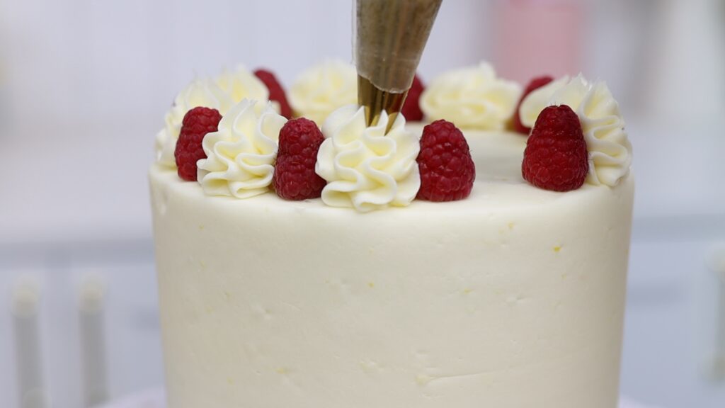 lemon and raspberry cake with piped 1M ruffle on top