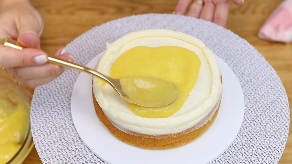 spoon and spread lemon curd filling onto cake