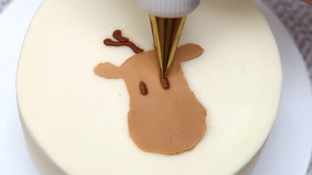 pipe eyes onto the reindeer with a small round piping tip