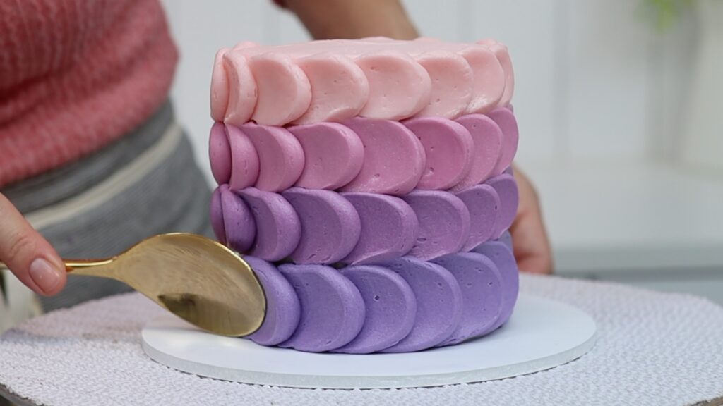 piping the bottom row of scallops on a cake